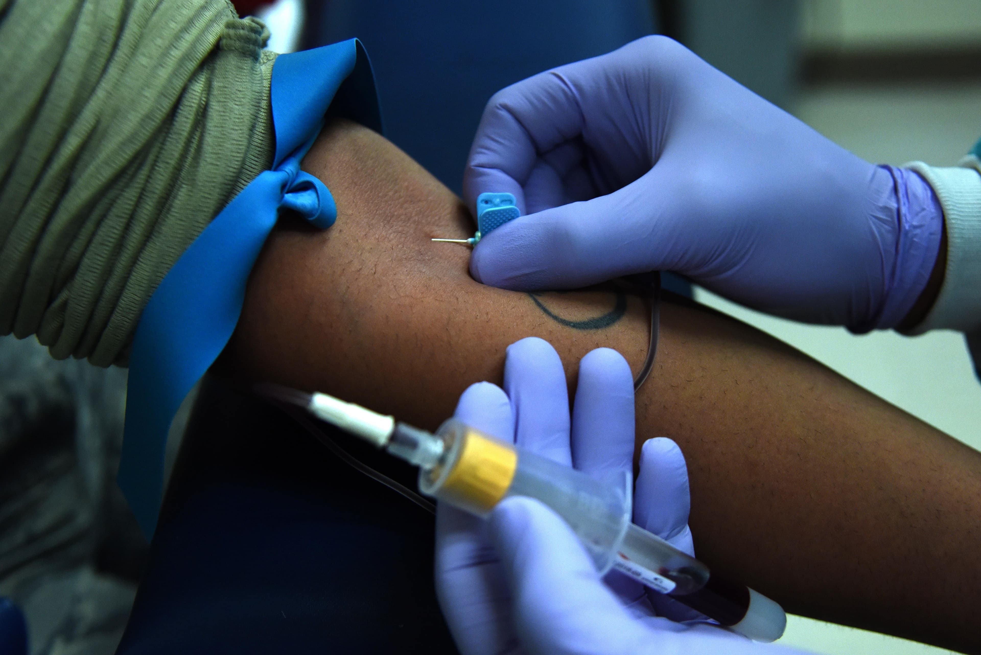 Clinical staff drawing a blood sample in a medical setting
