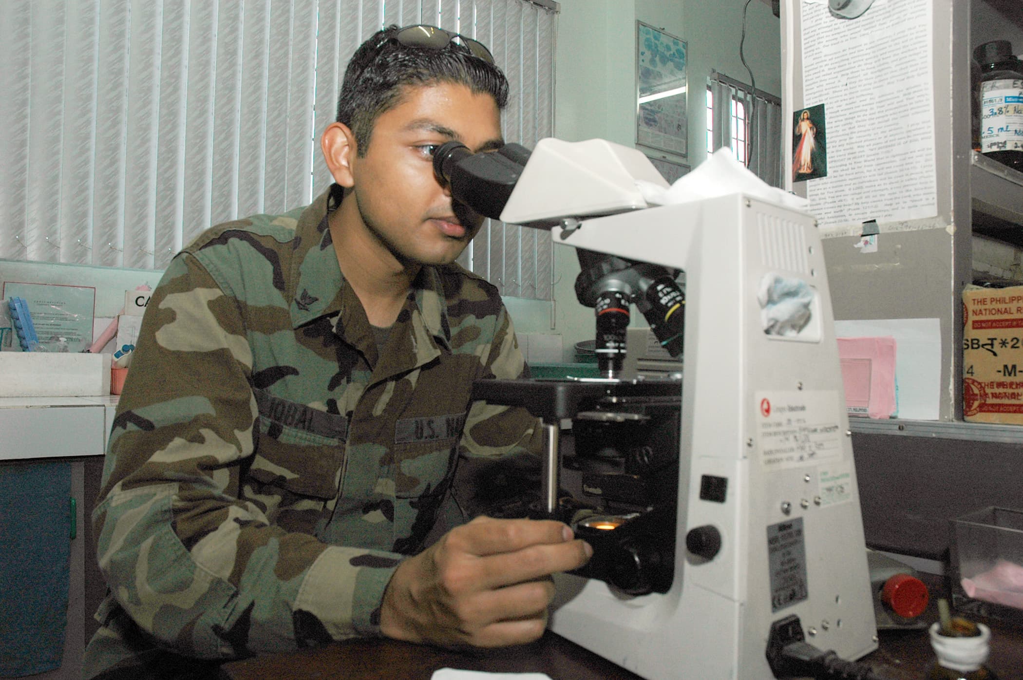 Laboratory professional examining blood chemistry under a microscope